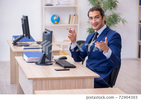 Young male employee working in the office 72904303