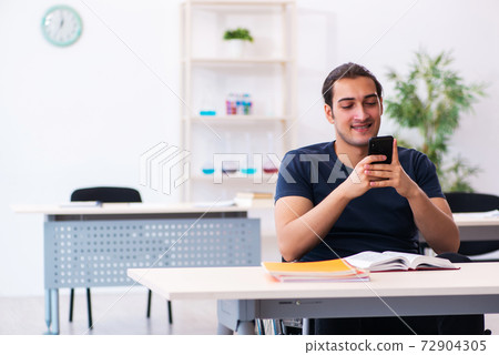 Young male student in wheel-chair preparing for exams 72904305
