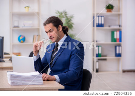 Young male employee working in the office Young male employee working in the office 72904336