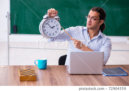 Young male teacher in time management concept Young male teacher in time management concept 72904359