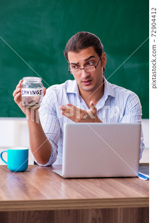Young male teacher in remuneration concept 72904412