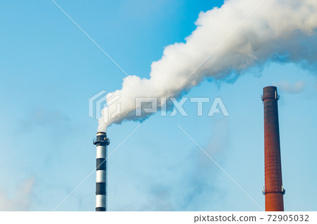 Chimney smoke at factory against blue sky Chimney smoke at factory against blue sky 72905032