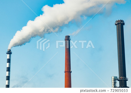 Chimney smoke at factory against blue sky Chimney smoke at factory against blue sky 72905033
