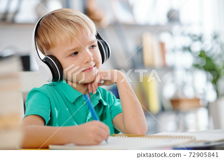 Cute schoolboy enjoying music 72905841