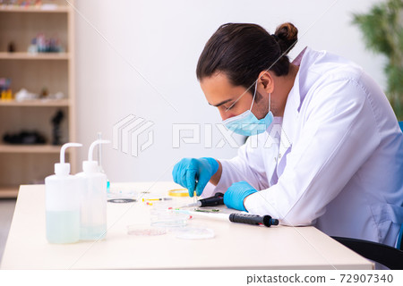 Young male chemist working in the lab during pandemic Young male chemist working in the lab during pandemic 72907340