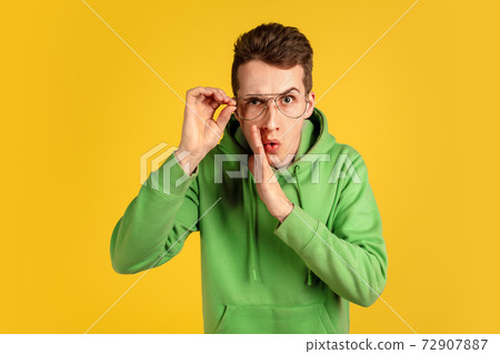 Portrait of young caucasian man isolated on yellow studio background Portrait of young caucasian man isolated on yellow studio background 72907887