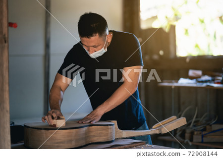 craft man making guitar on wood table, capenter working concept craft man making guitar on wood table, capenter working concept 72908144
