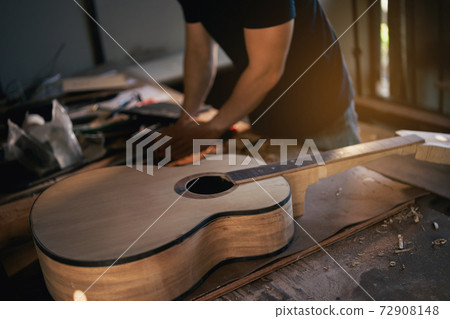craft man making guitar on wood table, capenter working concept 72908148