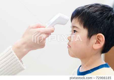 A boy who measures heat with a non-contact thermometer A boy who measures heat with a non-contact thermometer 72908185