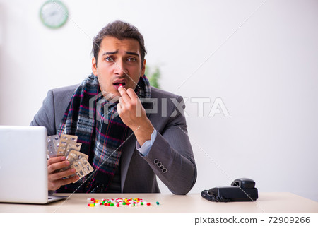 Young male employee suffering at workplace 72909266