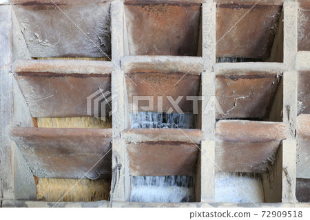 Brown rice flowing from old wooden rice milling Brown rice flowing from old wooden rice milling 72909518