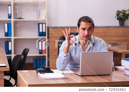 Young male employee working in the office Young male employee working in the office 72910361
