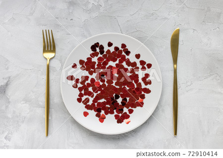 Gold cutlery, plate with hearts, gray background Gold cutlery, plate with hearts, gray background 72910414