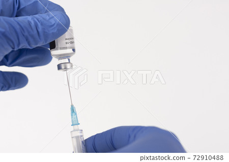 Close up human fingers in gloves, holding covid-19 vaccine vial and syringe with needle. Medical concept. Close up human fingers in gloves, holding covid-19 vaccine vial and syringe with needle. Medical concept. 72910488