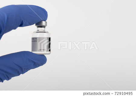 Fingers in gloves holding Covid-19 vaccine vial. Medical concept. Fingers in gloves holding Covid-19 vaccine vial. Medical concept. 72910495