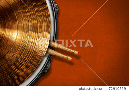 Golden Cymbal on a Snare Drum with two Wooden Drumsticks - Percussion Instrument Golden Cymbal on a Snare Drum with two Wooden Drumsticks - Percussion Instrument 72910539