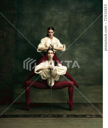 Two young female ballet dancers like duelists with swords. Ballet and contemporary choreography concept. Creative art photo. Two young female ballet dancers like duelists with swords. Ballet and contemporary choreography concept. Creative art photo. 72910855