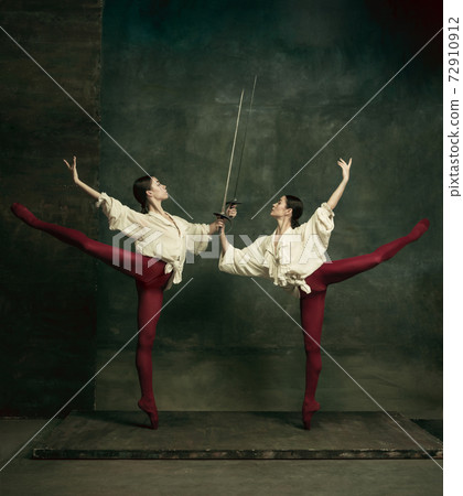Two young female ballet dancers like duelists with swords. Ballet and contemporary choreography concept. Creative art photo. Two young female ballet dancers like duelists with swords. Ballet and contemporary choreography concept. Creative art photo. 72910912