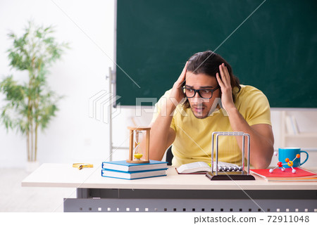 Young male student physicist preparing for exams in the classroo 72911048