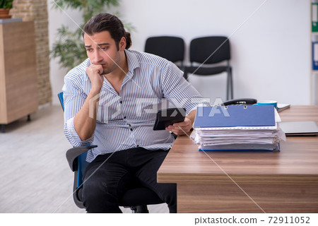 Young male bookkeeper working in the office Young male bookkeeper working in the office 72911052