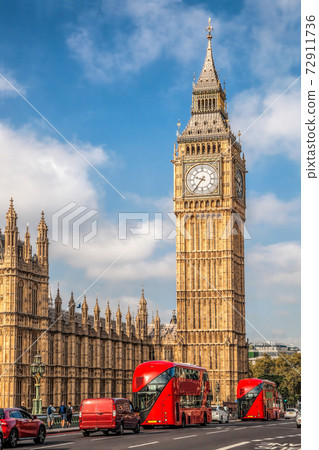 Big Ben with red buses on the bridge during sunny day in London, England, UK 72911736