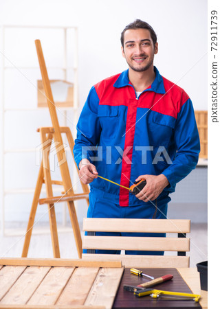 Young male contractor working in workshop 72911739