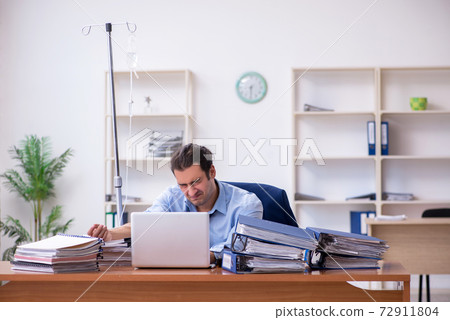 Young male employee suffering at workplace Young male employee suffering at workplace 72911804