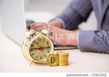 Young man earning money via Internet in time management concept 72911849