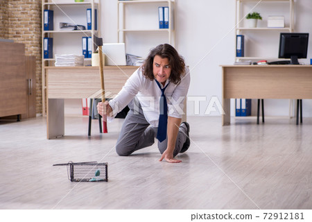Young male employee and mousetrap in the office Young male employee and mousetrap in the office 72912181