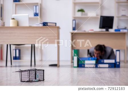 Young male employee and mousetrap in the office Young male employee and mousetrap in the office 72912183