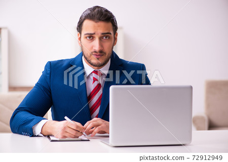 Handsome male realtor working indoors Handsome male realtor working indoors 72912949