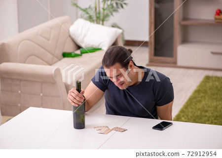 Young sick male alcoholic suffering at home 72912954