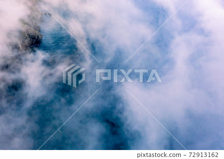 Dramatic aerial view of clouds from above at the Slieve League cliffs in County Donegal, Ireland Dramatic aerial view of clouds from above at the Slieve League cliffs in County Donegal, Ireland 72913162