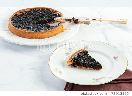 Cut blueberry tart with a cake slice 72913355