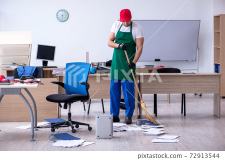 Young male contractor cleaning the office 72913544