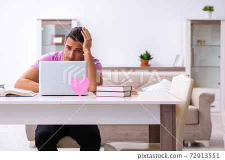 Male student in love preparing for exams at home Male student in love preparing for exams at home 72913551