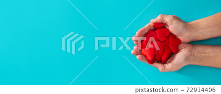 Woman hands holding red hearts on blue background 72914406