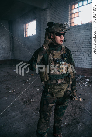 Soldier talking on the walkie-talkie inside the building, military concept 72914879