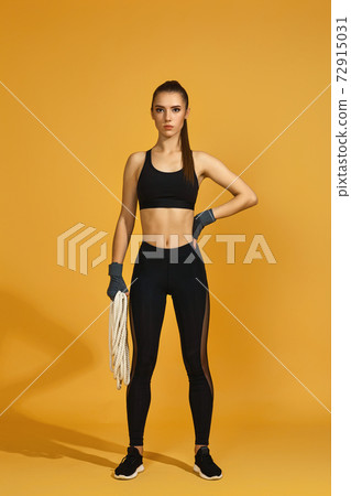 woman in black sportswear with heavy ropes woman in black sportswear with heavy ropes 72915031