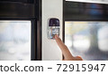 Finger pressing the get-off button inside the bus 72915947