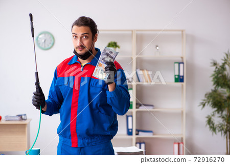 Young male contractor disinfecting office 72916270