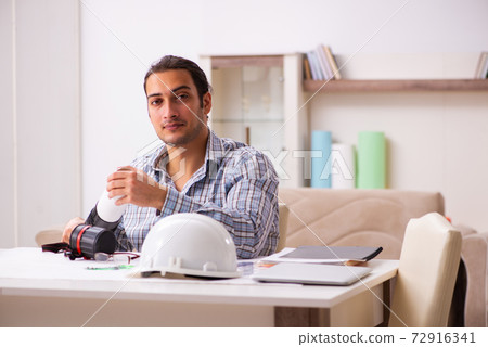 Young male architect working from house during pandemic 72916341