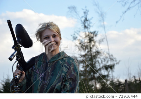 Paintball sport player girl in protective camouflage uniform 72916444