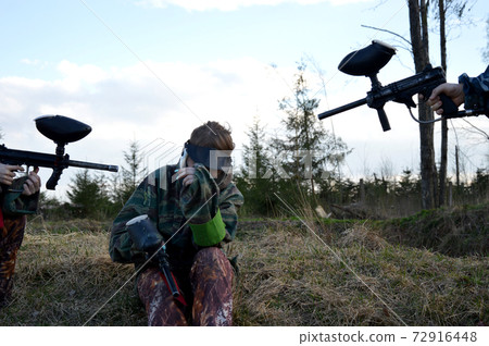 Paintball sport player girl in protective camouflage uniform Paintball sport player girl in protective camouflage uniform 72916448