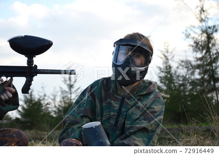 Paintball sport player girl in protective camouflage uniform 72916449