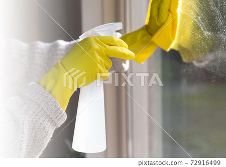 Cleaning a window with spray detergent, Yellow rubber gloves and dish cloth on work surface concept for hygiene, business and health concept 72916499