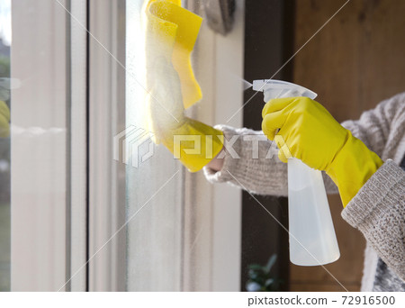 Cleaning a window with spray detergent, Yellow rubber gloves and dish cloth on work surface concept for hygiene, business and health concept 72916500