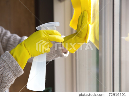 Cleaning a window with spray detergent, Yellow rubber gloves and dish cloth on work surface concept for hygiene, business and health concept 72916501