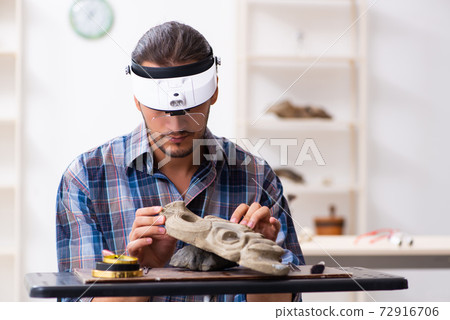 Young male archaeologist studying ancient african stonemask Young male archaeologist studying ancient african stonemask 72916706
