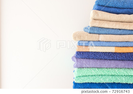 Lots of colorful bath towels stacked on each other. Isolated cotton towels for hotels, home, bathroom, kitchen Lots of colorful bath towels stacked on each other. Isolated cotton towels for hotels, home, bathroom, kitchen 72916743